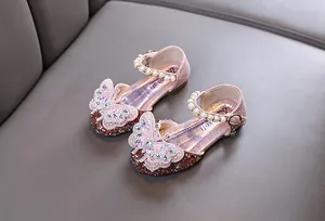 Detailed view of pink glitter princess shoes with butterfly rhinestone ornament and pearls