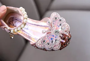 Detail view of pink girls' princess shoes with rhinestone butterfly and pearl strap