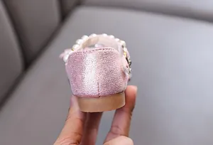 Detailed view of sparkly pink princess shoe heel featuring elegant faux pearl accents