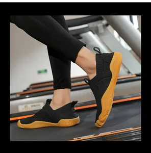 Action detail of black wide-toe knitted barefoot running shoes on a treadmill
