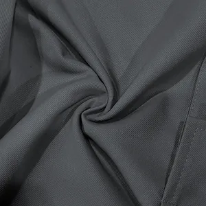 Macro view of dark grey men's cargo pants fabric showing fine diagonal twill texture detail