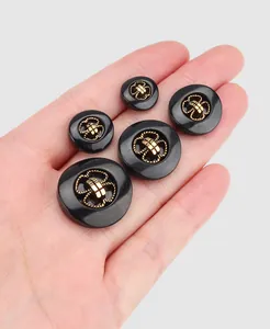 Close-up detail of premium black nylon buttons featuring vintage gold relief pattern design