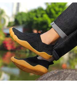 Close-up of black wide toe barefoot hiking shoes with tan gum sole on model outdoors