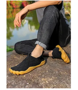 Outdoor detail of lightweight fly-knit barefoot shoes with wide toe box on a rock surface