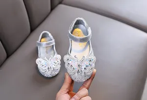 Close-up of silver girls' princess shoes featuring a sparkling rhinestone butterfly.