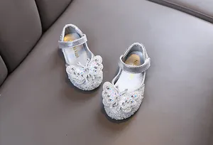 Detail showing sparkling rhinestones and butterfly on girls' silver princess dress shoes