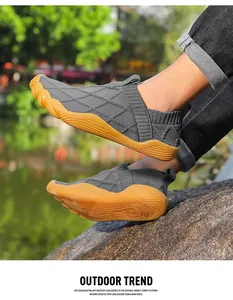 Close-up of lightweight grey fly-knit barefoot shoes on a rock outdoors