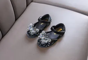 Close-up of sparkly rhinestone girls princess shoes featuring elegant butterfly detail