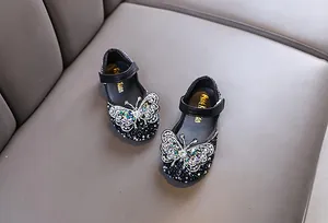 Close-up of girls princess dress shoes with sparkling butterfly rhinestone detail
