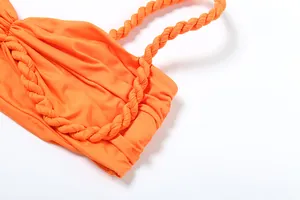 Detailaufnahme von orangefarbenem Stoff mit geflochtenem Träger für Damen-Set.