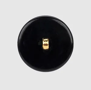 Vista dettagliata di un bottone in nylon nero lucido con un occhiello in metallo dorato