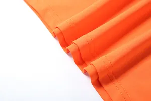 Makrodetail aus orangefarbenem Stoff mit hochwertigem doppelt genähtem Saum
