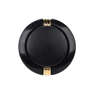 High-end black round clothing button featuring elegant gold ribbed metal accents