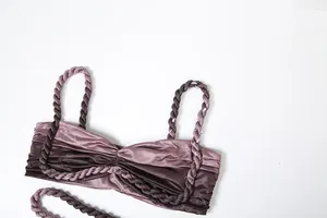 Nahaufnahme eines malvenfarbenen Satin-Tops mit gedrehten Seilträgern und Falten-Details.