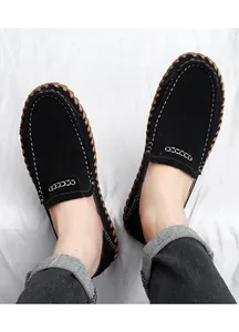 Vue de dessus de mocassins en daim noir avec détails cousus main et coutures blanches