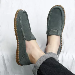 Mocassins pour hommes en daim gris faits à la main avec surpiqûres traditionnelles portés au pied