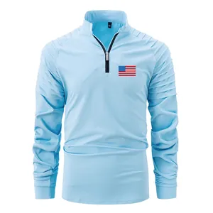 Detailed view of light blue men's half-zip long sleeve polo with pleated shoulders