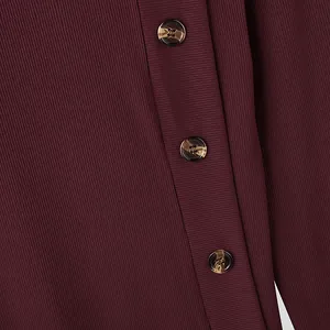 Detail macro view of brown buttons on burgundy ribbed knit men's long sleeve shirt.