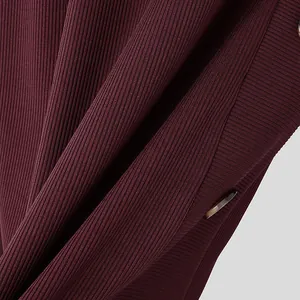 Macro view of premium burgundy ribbed knit fabric featuring a stylish marble button detail