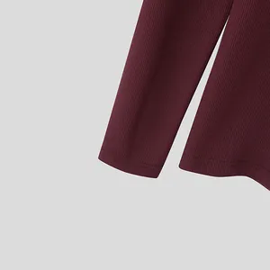 Detailed close-up view of maroon ribbed knit fabric showing sleeve cuff and hem stitching