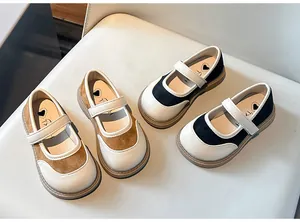 Dettaglio delle scarpe Mary Jane da bambina in pelle marrone e nera molto elegante.