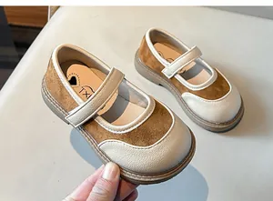 Dettaglio di scarpe Mary Jane bicolore per bambina con suole morbide e finitura crema elegante