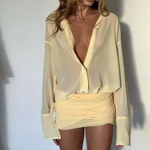Dettaglio di un completo sexy giallo pallido con camicia velata e minigonna