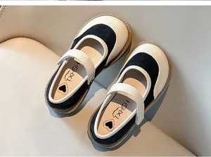 Dettaglio ravvicinato di scarpe Mary Jane nere e bianche per bambine con suola morbida.