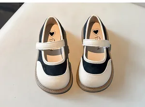 Primo piano di scarpe Mary Jane nere e bianche per bambina con solette decorate a cuore.