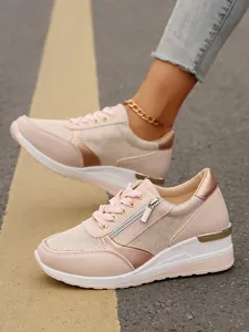Detailed view of pink platform sneakers with side zipper and rose gold accents.