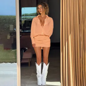 Dettaglio di un abito a camicia aderente arricciato color pesca con scollo a V profondo