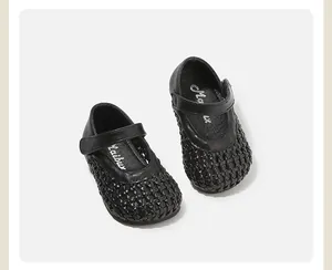 Close-up of black woven children's princess shoes with Velcro straps and hollow design.