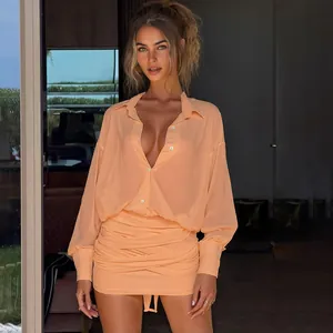 Primo piano di un abito a camicia aderente arricciato color pesca con maniche e revers