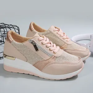 Close-up of pink wedge sneakers with side zipper and metallic rose gold trim detail.