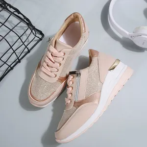 High-angle close-up view of pink platform sneakers featuring side zippers and gold accents