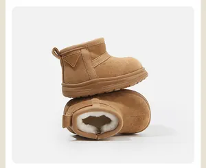 Detail of brown kids' snow boots with warm white faux fur lining and suede texture.