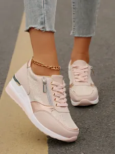Detailed view of women's pink platform sneakers featuring a stylish side zipper design