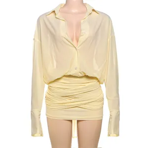 Vista dettagliata di un abito a camicia a maniche lunghe giallo pallido con gonna a bende.