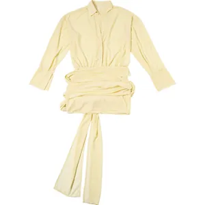 Vista ravvicinata di un elegante abito a camicia crema a maniche lunghe con lacci