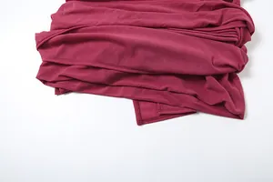 Dettaglio ravvicinato del pregiato tessuto bordeaux di un abito a camicia aderente da donna