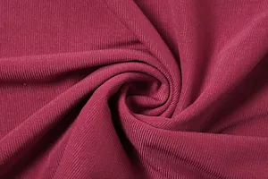 Primo piano della morbida trama a coste e del colore rosso vino intenso di questo abito chic