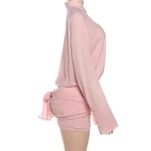Vista laterale di un vestito a camicia rosa sexy con maniche lunghe e nodo elegante