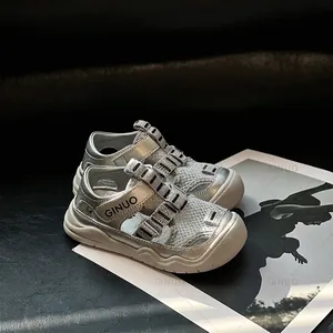 Macrobeeld van zilveren mesh peutersandalen met zachte zolen en een gesloten teenontwerp