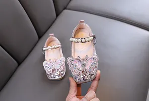 Détail des chaussures de princesse roses pour filles avec papillon en strass et perles