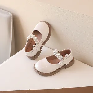 Elegantes zapatos Mary Jane crema para niñas con correa de perlas y detalle de lazo.