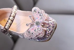 Vue détaillée d'une chaussure de princesse à paillettes avec perles et un papillon