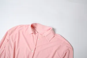 Dettaglio ravvicinato di un abito a camicia rosa con colletto e bottoni