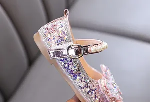 Détail d'une chaussure de princesse rose pailletée avec perles pour fille