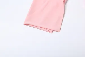 Dettaglio ravvicinato della trama del tessuto rosa morbido di un abito a camicia