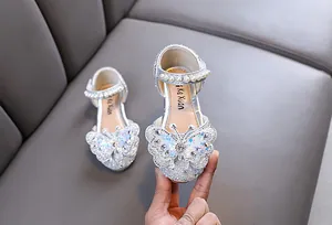 Detail of silver girls princess shoes featuring a sparkly butterfly and pearl strap
